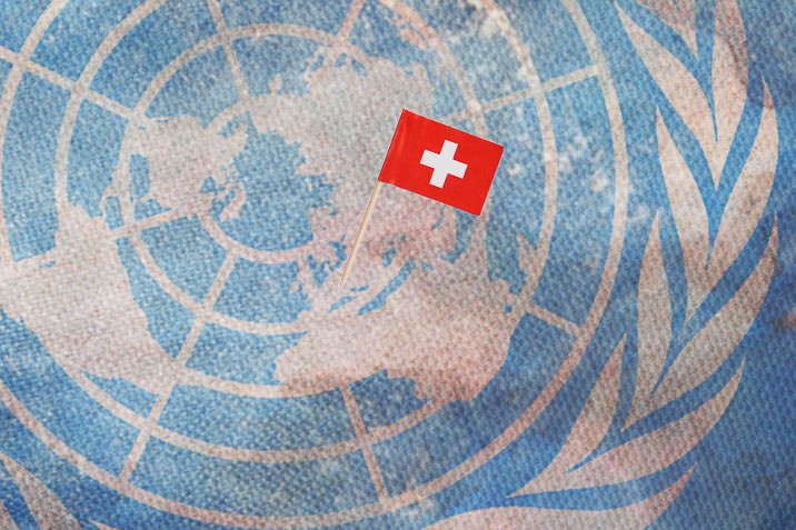 Das Bild zeigt das UNO Logo mit einem Schweizer Fähnchen