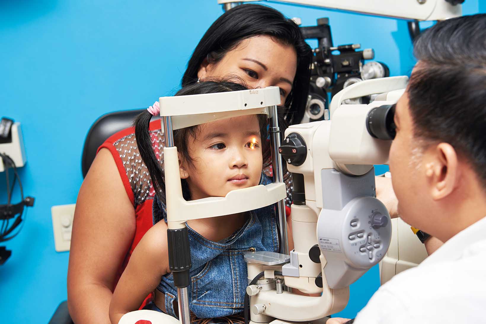 Ein Mädchen mit Grauem Star aus den Philippinen wird von einem Augenarzt mittels Spaltlampe untersucht.