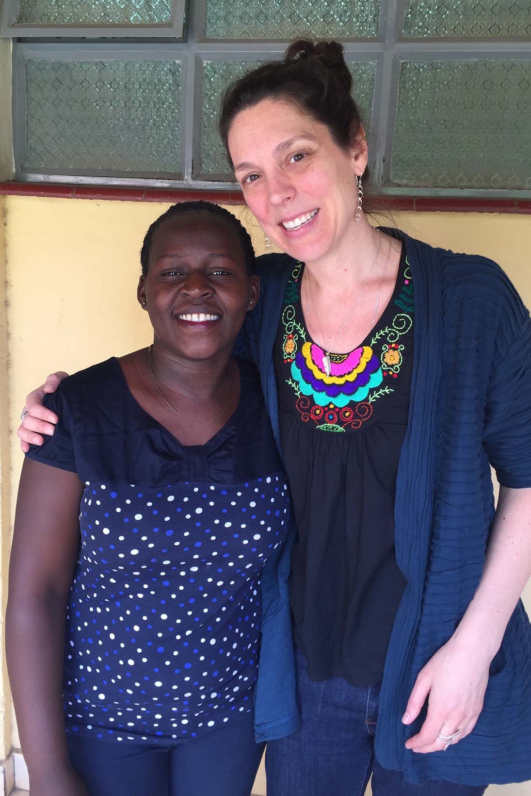 Zwei Frauen - eine aus dem Südsudan, die andere aus den USA - stehen nebeneinander und lächeln in die Kamera.