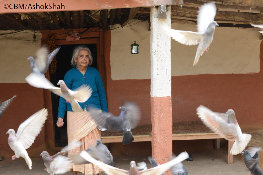 Tika Niraula beim Füttern von Tauben vor ihrem Haus.