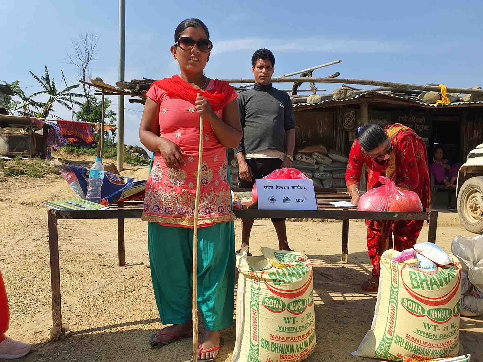 Eine blinde Frau aus Nepal steht bei einer Abgabestelle für Nothilfe-Pakete.