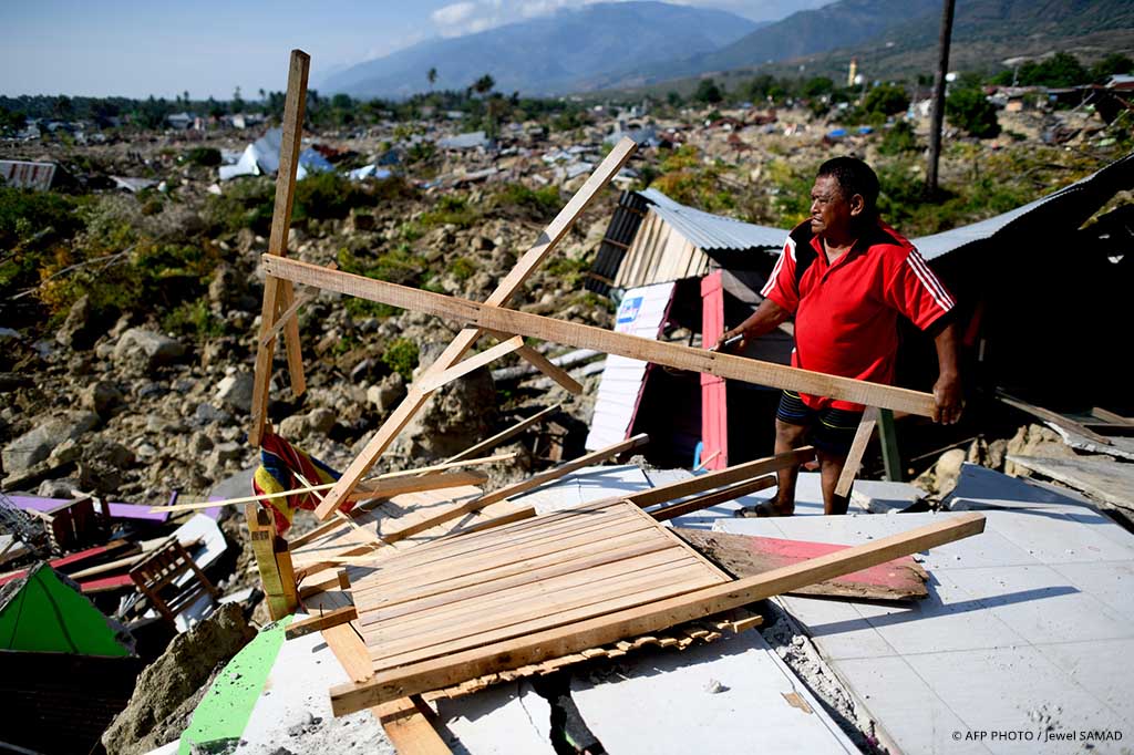Ein Mann steht nach einem Tsunami auf Sulawesi inmitten von Trümmern.