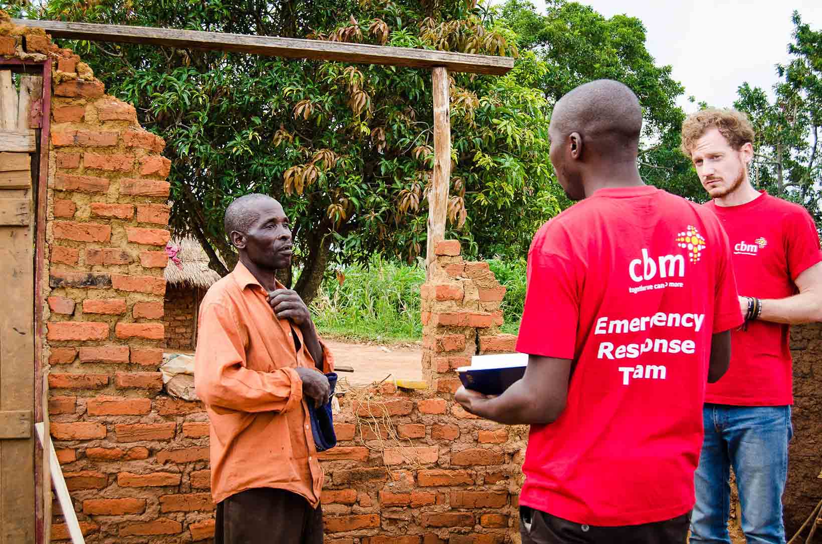 In Zimbabwe, due uomini parlano con una vittima del ciclone Idai.