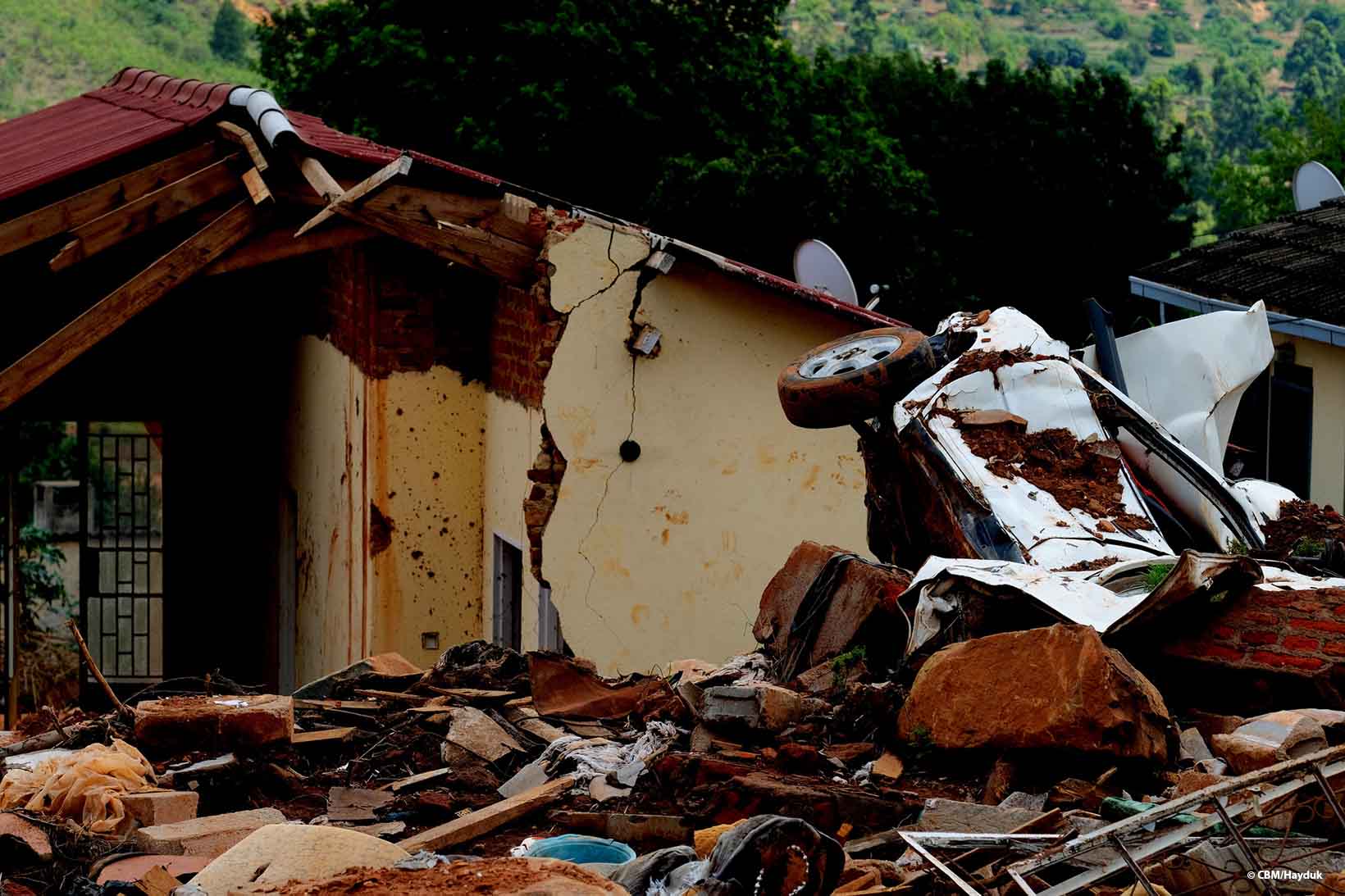 Una casa sventrata dal ciclone Idai in Zimbabwe. In primo piano si vedono un’auto completamente distrutta e una montagna di detriti.