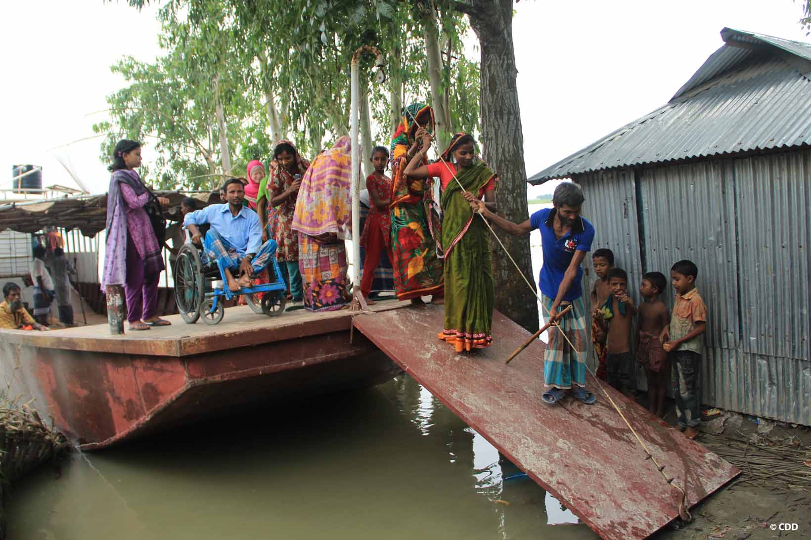 Des habitants du Bangladesh montent dans un bateau de sauvetage sans barrières.