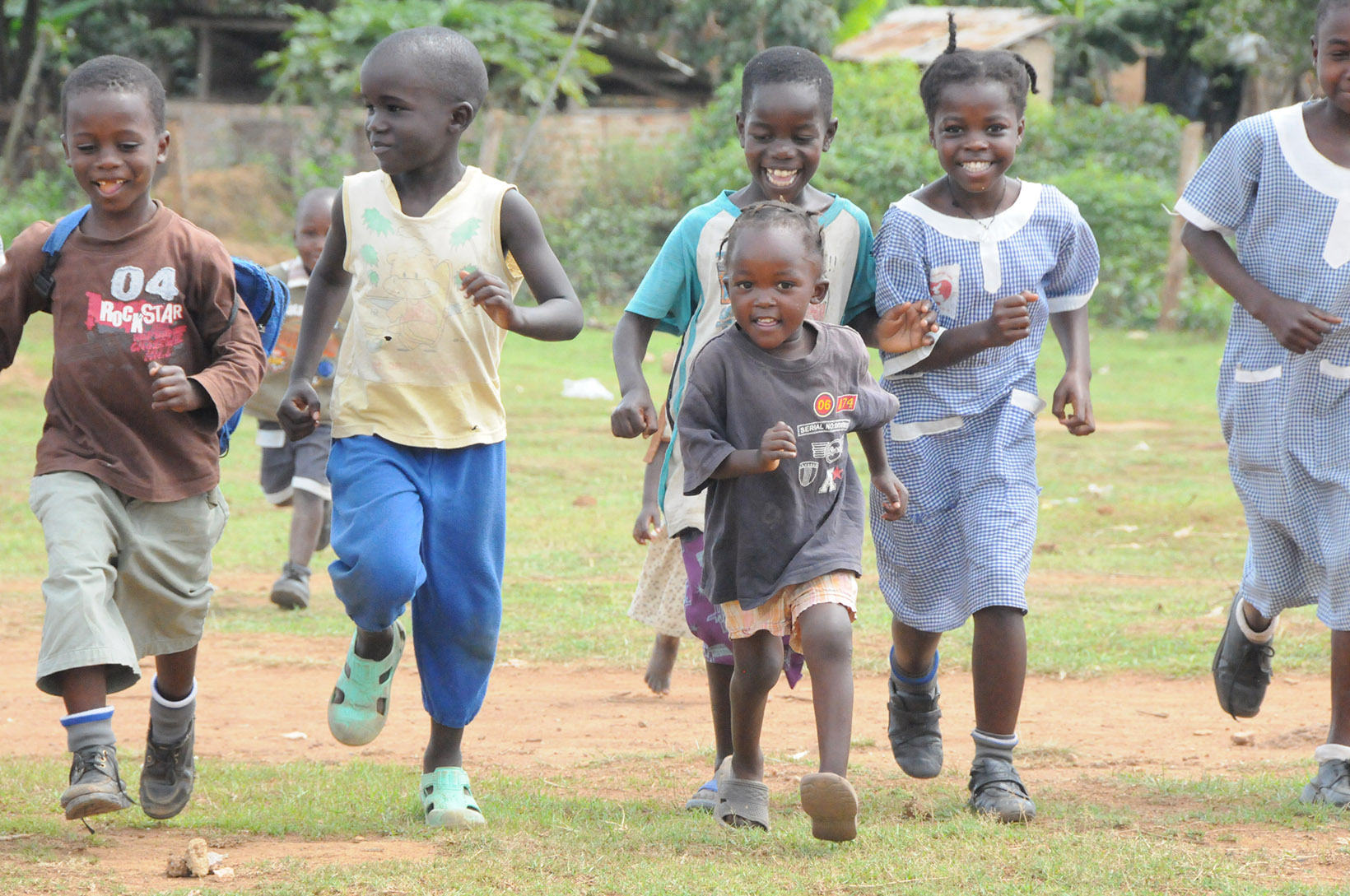 Una ragazza ugandese corre con altri bambini.