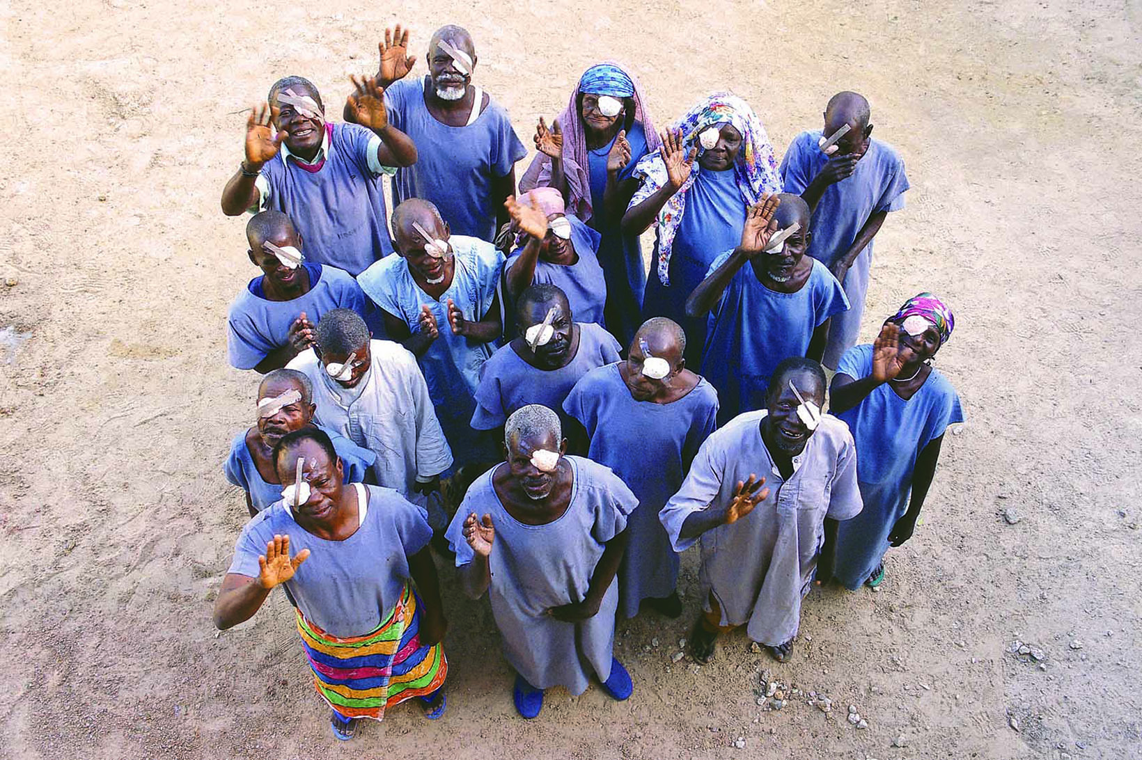 Eine Gruppe von winkenden Menschen mit Augenklappen
