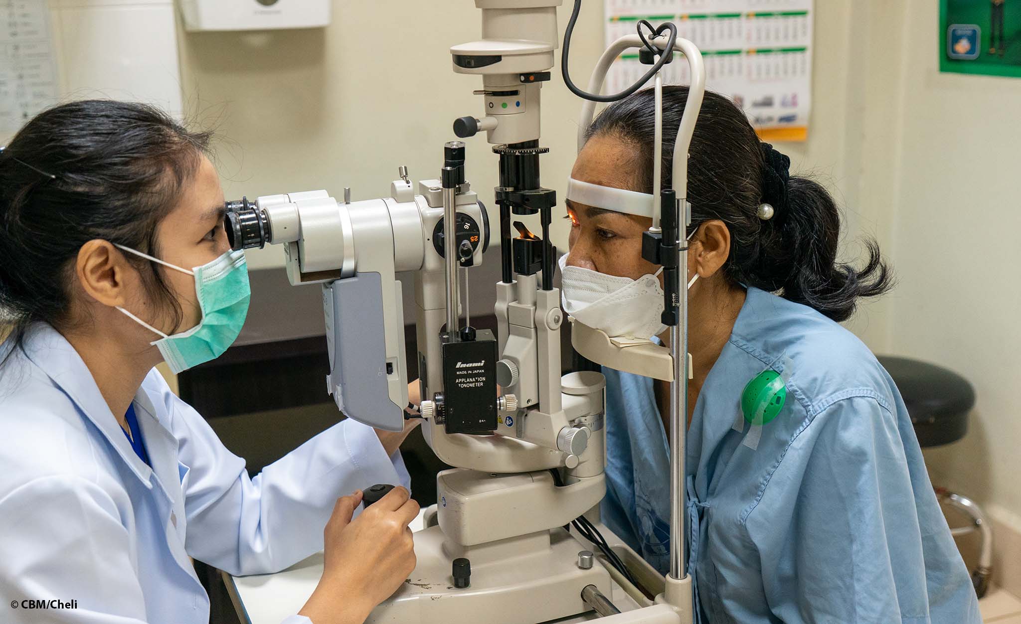 Une chirurgienne ophtalmologique du Laos examine les yeux d'une femme.